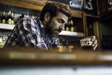 Sad man sitting in beer bar