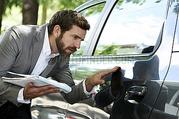 Salesman examining car