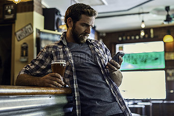 Man using smartphone in beer bar