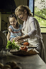 Grandmother and granddaughter preparing food