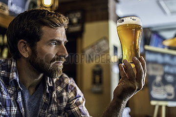 Man looking at beer glass
