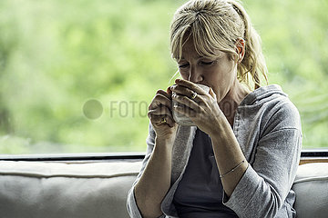 Mature woman having coffee at home