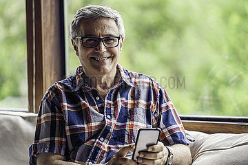 Portrait of mature man using smartphone