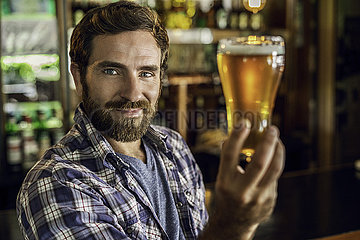 Smiling man holding a beer glass