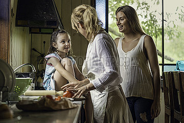 Mature woman talking with her granddaughter in kitchen