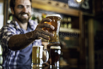 Smiling man serving beer