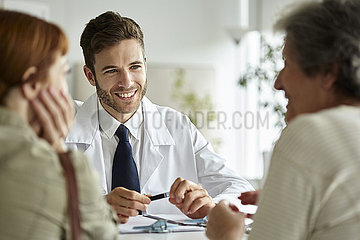 Smiling doctor talking with senior patient