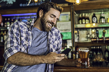 Man using smartphone in beer bar