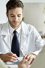 Doctor writing prescription in clinic