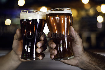 Hands toasting beer glasses