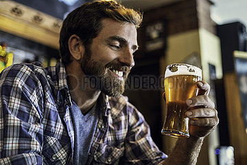 Man looking at beer glass