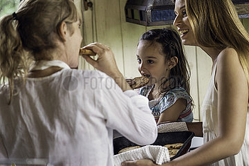Grandmother and granddaughter having cookies in kitchen
