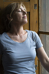 Mature woman standing near window