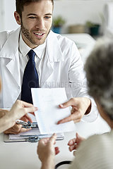 Doctor giving prescription to patient