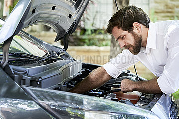 Man checking car engine