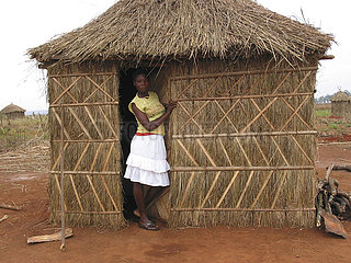 A woman stands in the doorway of a hut in Angola. Feeding centres and other humanitarian aid were organised in Angola after widescale malnutrition during and following the countrys civil war.