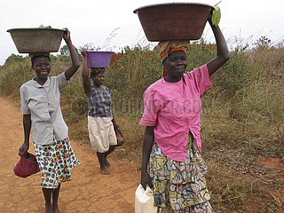 Woman carrying baskets with food on their heads. Feeding centres and other humanitarian aid were organised in Angola after widescale malnutrition during and following the countrys civil war.