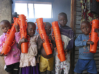 A groupu of children holding stacks of feeding cups at an MSF feeding clinic in Angola. Feeding centres and other humanitarian aid were organised in Angola after widescale malnutrition during and following the countrys civil war.
