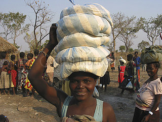 An Angolan woman displays her bags of food carried on her head. Feeding centres and other humanitarian aid were organised in Angola after widescale malnutrition during and following the countrys civil war.