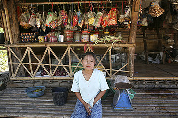 A shopkeeper in front of her store in a displaced persons camp near the border with Thailand. In Myanmar (Burma)  thousands of people have settled near the border as a result of oppression in their homeland. Around 200 Burmese displaced people have settle
