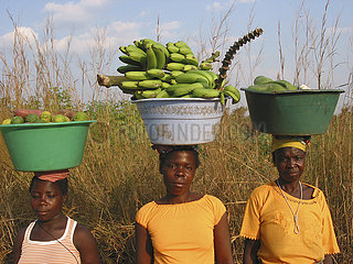 Women carrying fresh fruit on their heads in Angola. Feeding centres and other humanitarian aid were organised in Angola after widescale malnutrition during and following the countrys civil war.