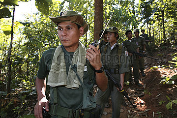A KNLA soldier listening to a radio device near the border with Thailand. In Myanmar (Burma)  thousands of people have settled near the border as a result of oppression in their homeland. Around 200 Burmese displaced people have settled in La Per Her  a v