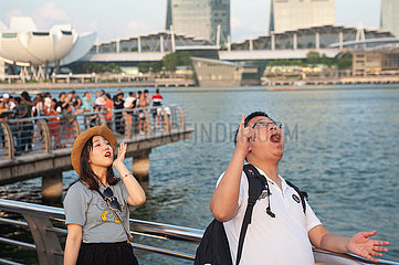 Singapur  Republik Singapur  Touristen am Singapore River mit Marina Bay Sands Hotel