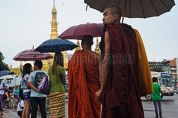 Yangon  Myanmar  Moenche und Menschen an einer Bushaltestelle im Stadtzentrum