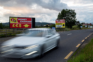 Irland  Dundalk - Werbung fuer Wechselstube direkt auf der irischen Grenze an einer Landtrasse Richtung Belfast (nach rechts)
