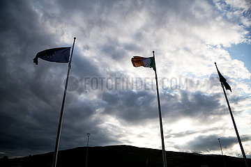 Irland  Dundalk - Irische Grenze: Irische Fahne eingerahmt von zwei EU-Fahnen  die Berge gehoeren zu Nordirland