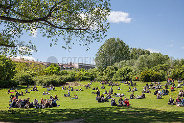 Besucher des Goerlitzer Parks sitzen am 1. Mai auf der Wiese in Berlin-Kreuzberg