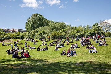 Besucher des Goerlitzer Parks sitzen am 1. Mai auf der Wiese in Berlin-Kreuzberg