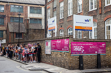 Jugendliche warten weit entfernt auf Einlass in das Geschaeft der Marke Supreme in London