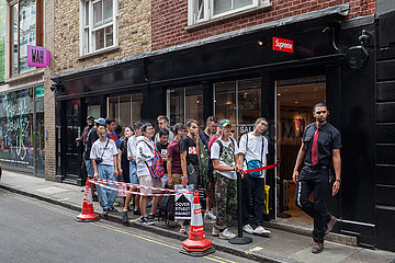Jugendliche warten auf Einlass vor einem Geschaeft der Marke Supreme in London