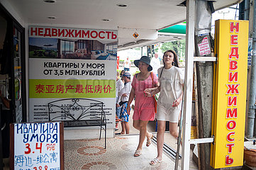 Phuket  Thailand  Touristen vor einem Verkaufsbuero mit Schildern in kyrillischer Schrift