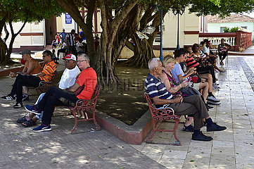 Kuba  Baracoa-Kubaner sitzen auf Parkbaenken im Stadtzentrum