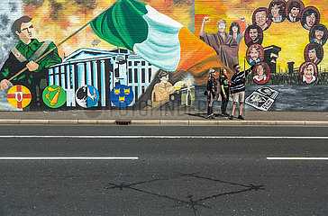 Grossbritannien  Nordirland  Belfast - junge Touristen  Politische Wandmalerei  Falls Road  katholisches West Belfast