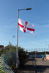 Grossbritannien  Nordirland  Belfast - Protestantischer Teil von West Belfast  Ulster Fahne am Peace Wall  der Stadtteil nach Konfession teilt