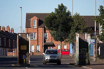 Grossbritannien  Nordirland  Belfast - Tagsueber offenes Tor am Peace Wall (teilt Stadtteil nach Konfession)  protestantischer Teil von West Belfast.