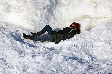 Helsinki  Finnland  Frau liegt im Schnee und sonnt sich