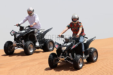 Dubai  Vereinigte Arabische Emirate  Jugendliche fahren auf Quads durch die Wueste