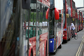 London  Grossbritannien  Fahrradfahrer schlaengelt sich zwischen im Stau stehenden Bussen hindurch