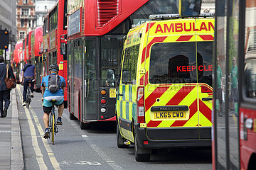 London  Grossbritannien  Fahrradfahrer fahren an im Stau stehenden Bussen und einem Krankenwagen vorbei
