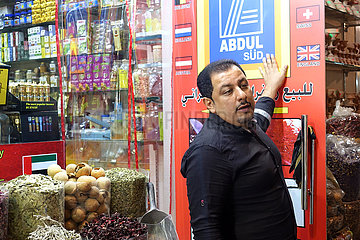 Dubai  Vereinigte Arabische Emirate  Haendler in einem Souq steht vor seinem Ladenschild Abdul Sued