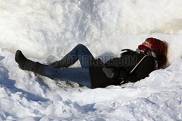 Helsinki  Finnland  Frau liegt im Schnee und sonnt sich