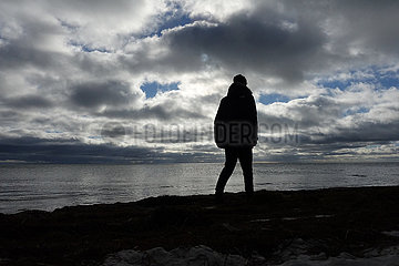 Braenna  Schweden  Silhouette  Junge geht allein am Strand spazieren