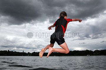 Berlin  Deutschland  Junge springt bei Gewitterwetter ins Wasser der Spree