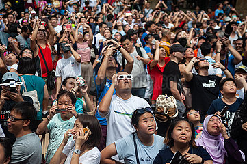 Singapur  Republik Singapur  Menschen beobachten die ringfoermige Sonnenfinsternis