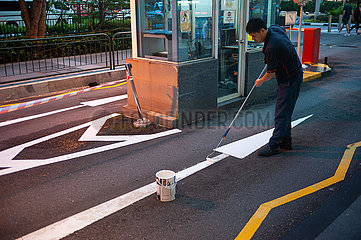 Singapur  Republik Singapur  Arbeiter streicht den Pfeil einer Strassenmarkierung an