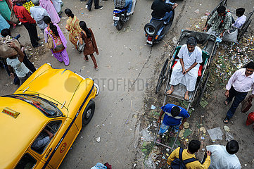 Kalkutta  Indien  Strassenszene mit Fussgaengern  Rikscha und Taxi